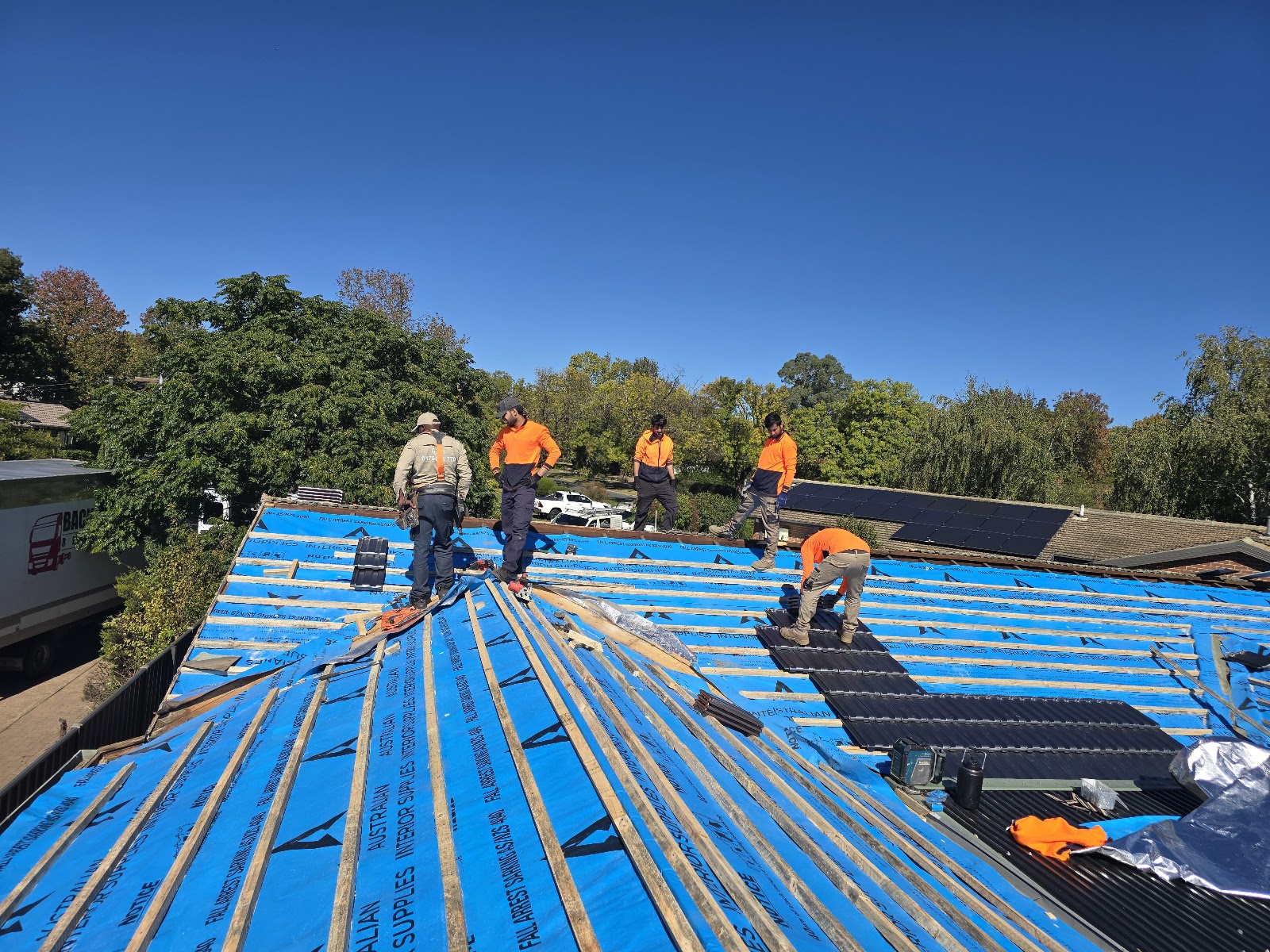 The crew on a stripped roof laying new sarking and battens before the new roof goes back on