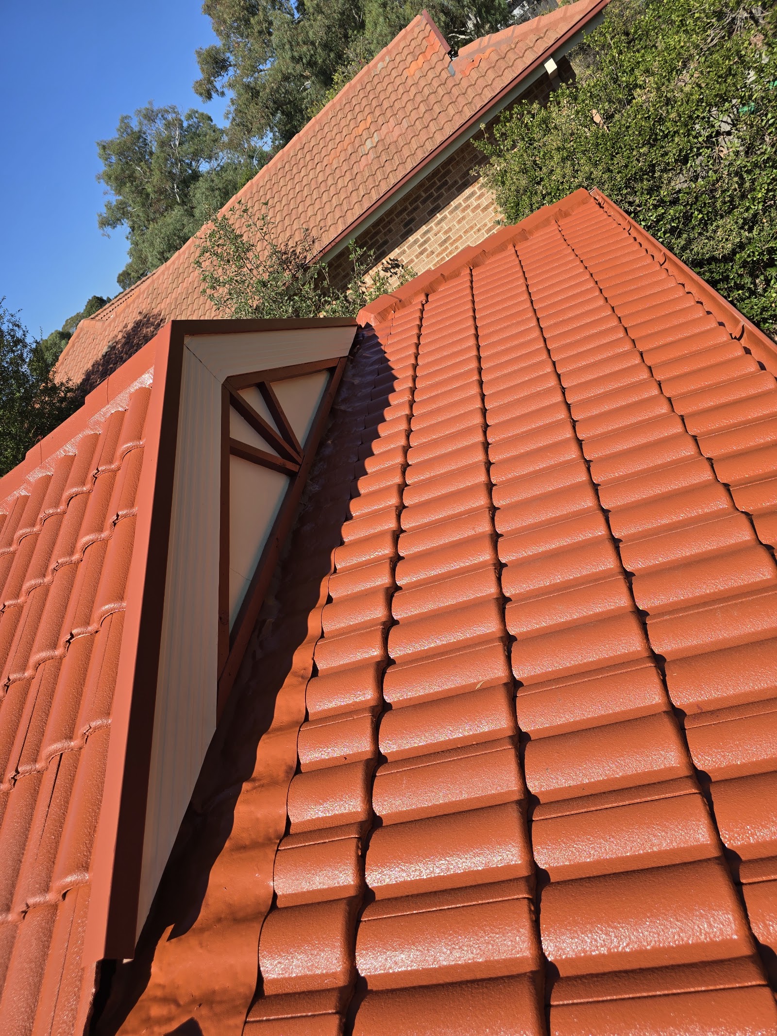 A terracotta tile roof with a fresh, even coat of paint