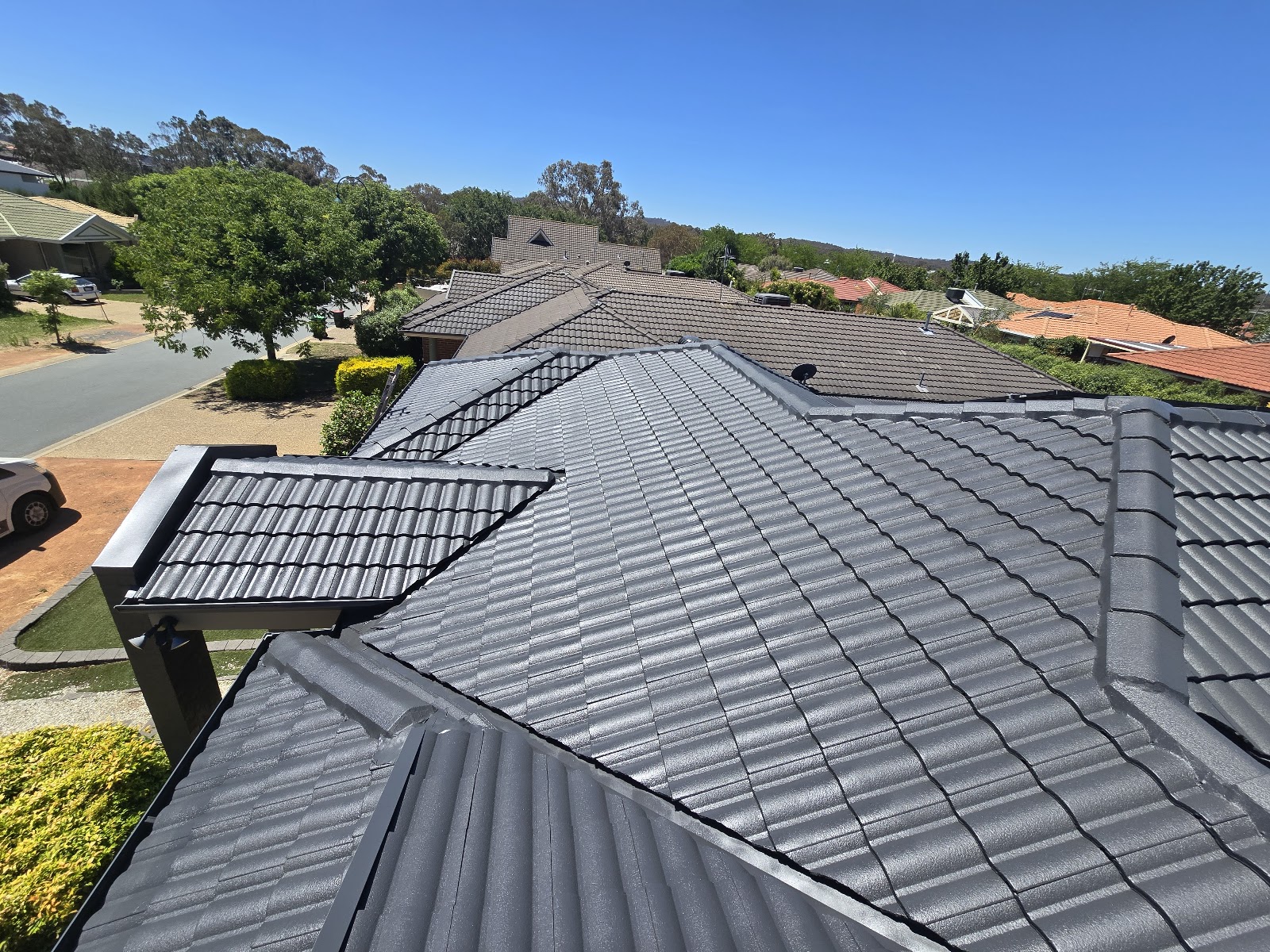 A Canberra tile roof after restoration and painting, finished in charcoal