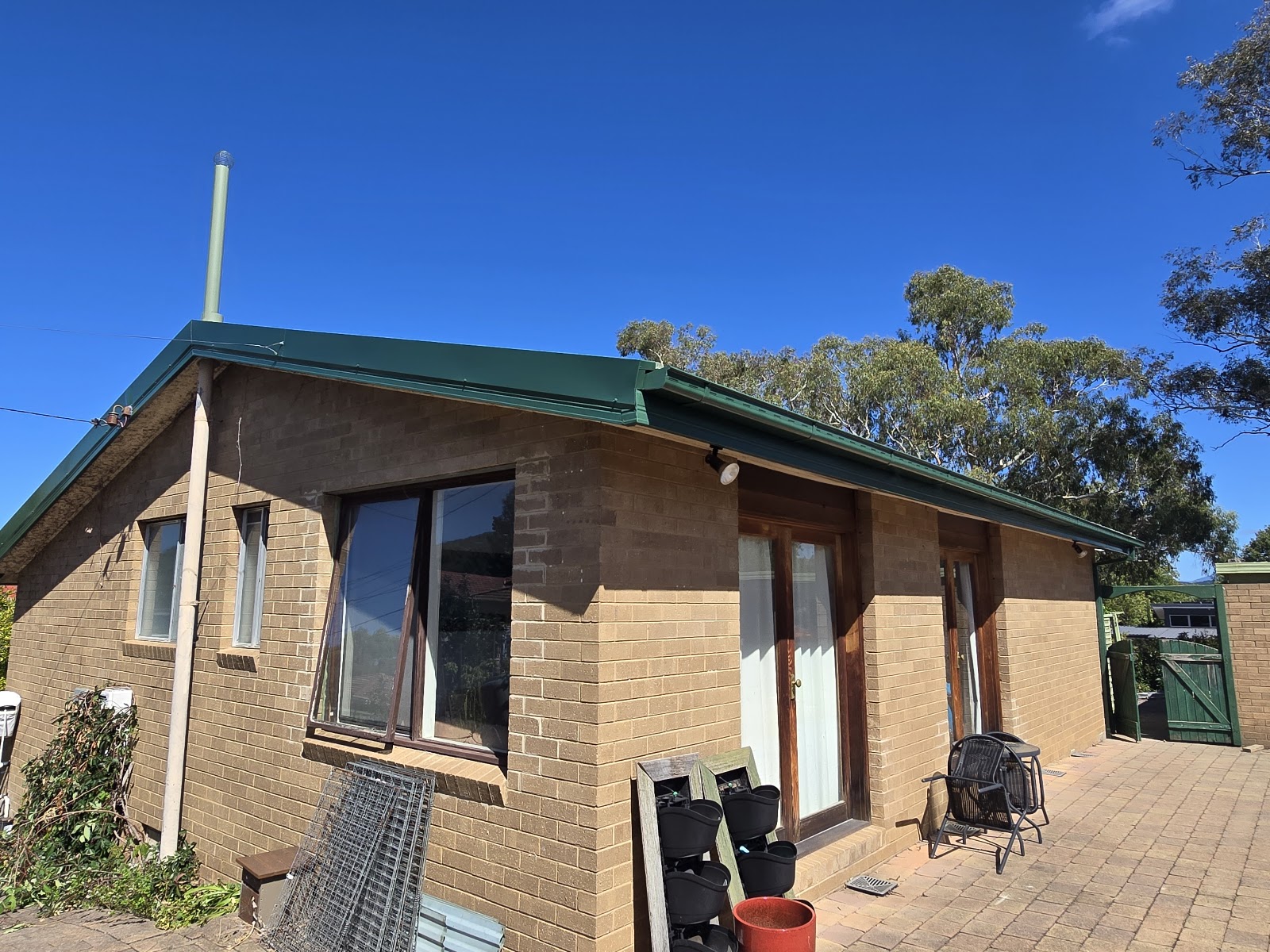 Brick home with new green guttering and fascia along the roof line